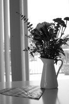 A vase of flowers on a kitchen table.