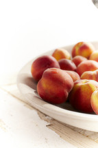 A cluster of peaches set in a bowl.