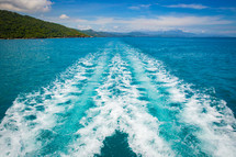 boat trail on blue ocean waters 