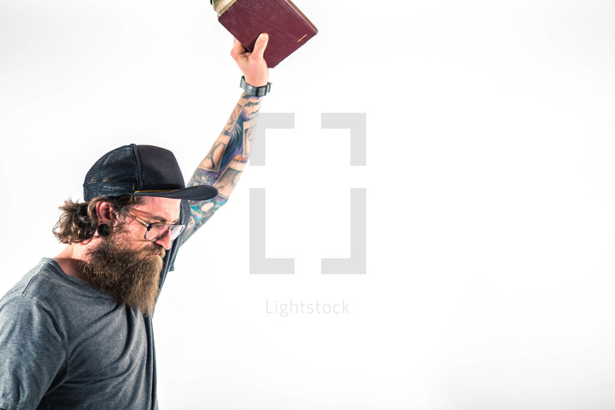 man holding a Bible up in worship to God 