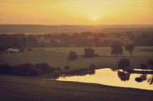 farmland and a pond at sunrise