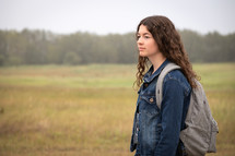 teen girl standing outdoors with a backpack 