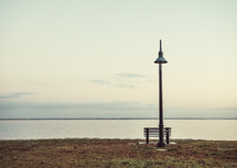 lamp and bench along a shore 