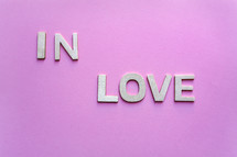 in love wooden letters on the pink background