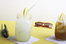 lemonade and iced tea on a table with sunglasses 