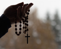 hand holding up a rosary 
