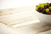 A bowl of green and red grapes