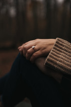 Woman and man holding hands with engagement ring showing
