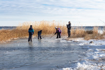 kids playing hockey with sticks on a family pond 