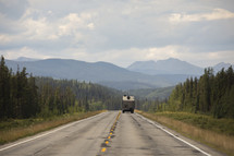 camper driving down a road 