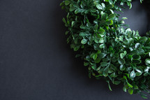 Simple green wreath on a black background with copy space