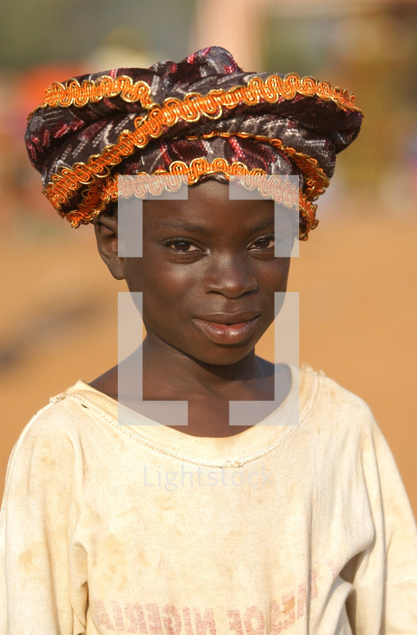 African child standing wearing a native hat