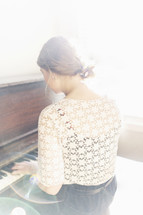 woman playing a piano in sunlight 