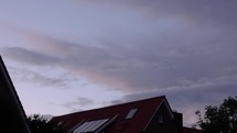 Day To Night Motion Timelapse - Clouds Moving In The Sky Above The House From Sunset To Nighttime
