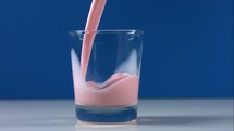pouring a glass of strawberry milk 
