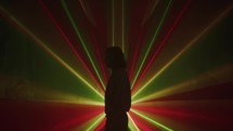 silhouette of a girl standing with a light show 