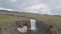 Fly over waterfall of volcanic river in Iceland
