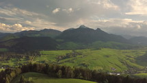 Aerial view of green alpine country in sunny spring nature landscape
