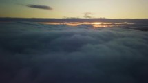 Epic flying above clouds at sunrise. Aerial slow motion with golden morning colors
