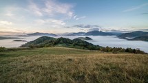 Foggy morning sunrise with clouds moving over beautiful country in mountains time lapse

