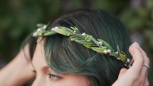 Beautiful nymph woman with dyed green hair and forest leaves crown. Cosplay wedding, elf princess in fairy tiara, fantasy make-up