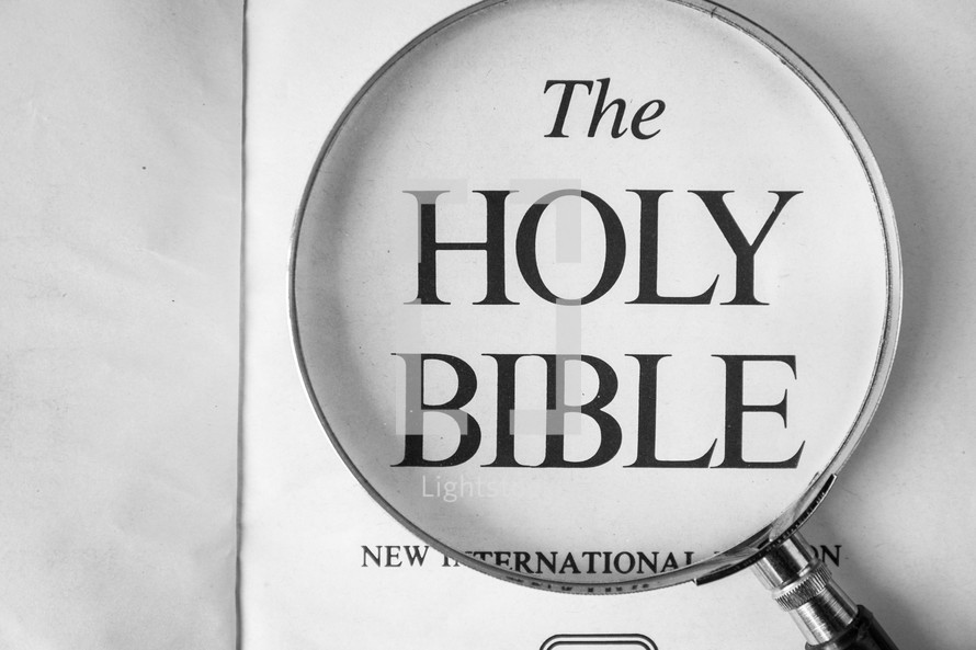 magnifying glass over the Holy Bible cover 