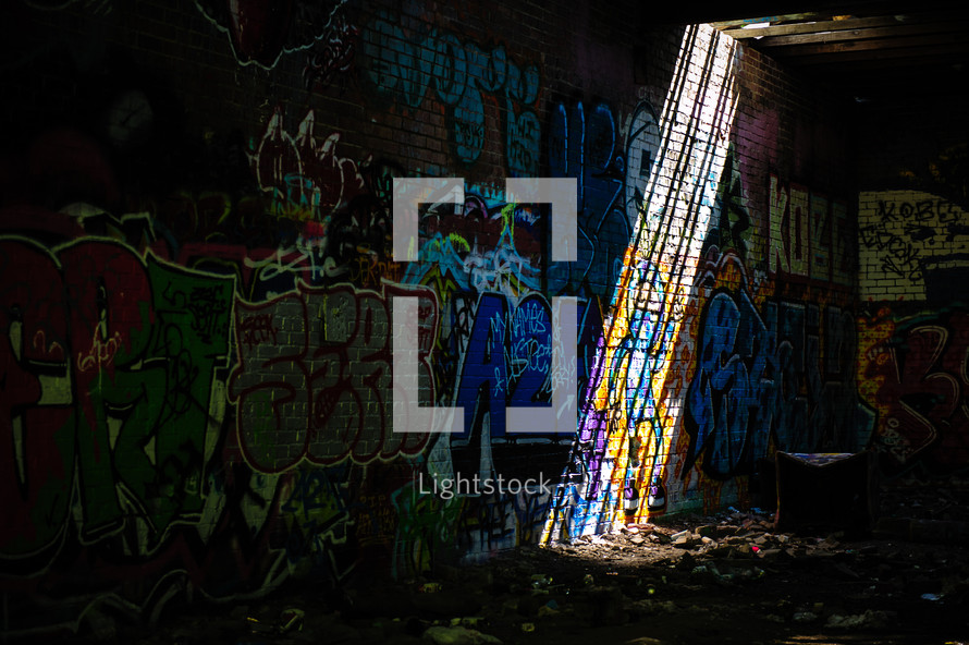 rays of sunlight shining on a graffiti covered wall 