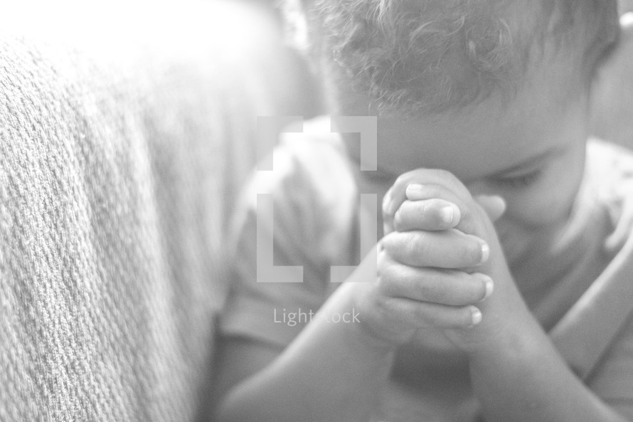 a toddler in prayer 