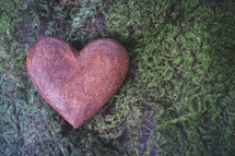 heart shaped stone on moss 