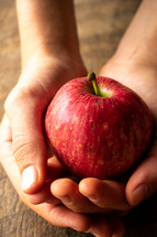 holding an apple in cupped hands 