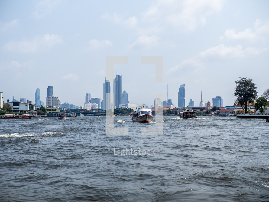 boat in the water with city skyline in the background 