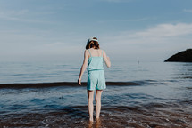 a girl standing in the ocean 