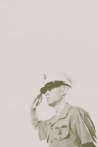 Vintage look of Marine soldier, in uniform, saluting.