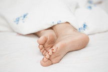 bare feet and woman under a blanket 