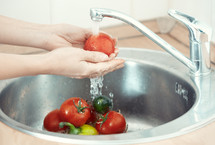 washing vegetables in a sink 