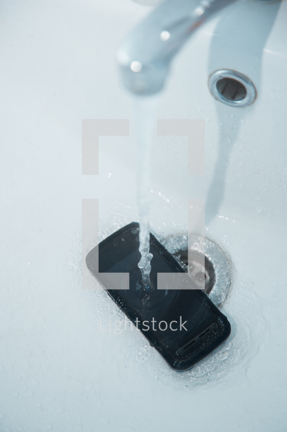 smartphone in sink with flowing water