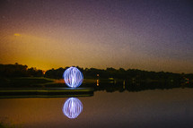 glowing ball of light and a lake 