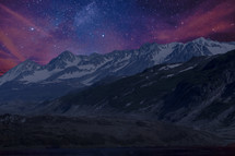 stars in the night sky over snow capped mountains 