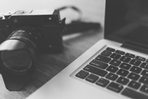 camera beside a laptop
