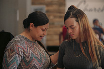 a mother and daughter praying together at church 