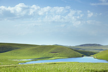 blue lake and green rolling hills 