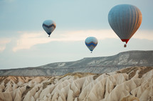 hot air balloons over desert canyon 