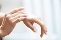 putting lotion on hands 