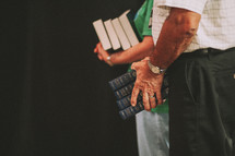 A man and woman with their hands full of Bibles.