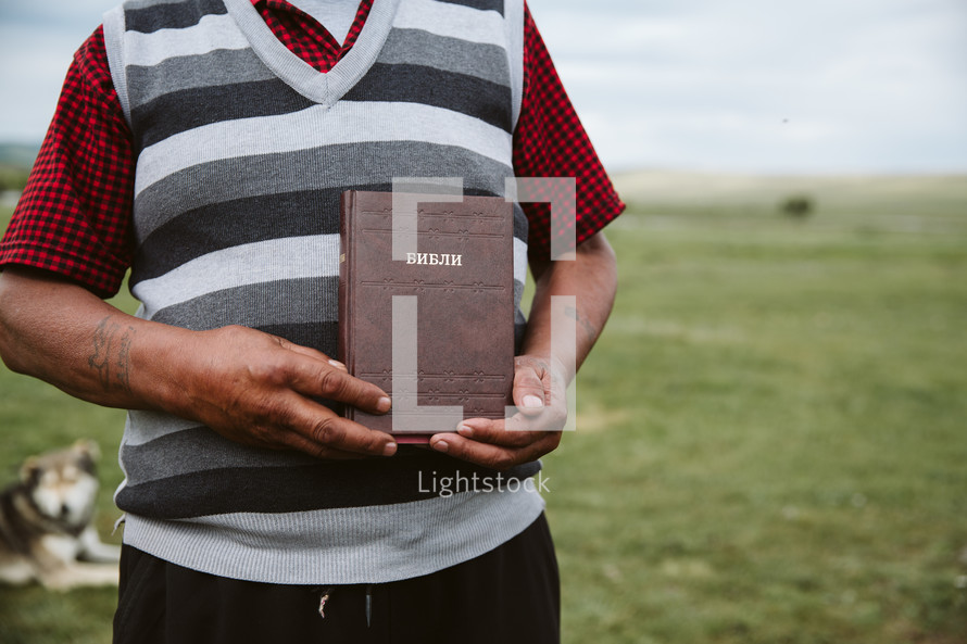 man holding Mongolian Bible