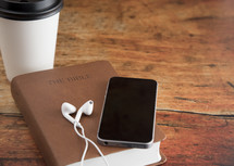 Bible and a Smart Phone with Earphones on a Wood Table