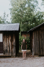 teen girl standing by cabins 