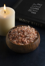 candle and bowl of pink Himalayan salt with Bible 