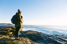 woman standing on a rocky shore 