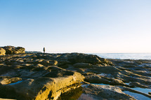 woman standing on a rocky beach 